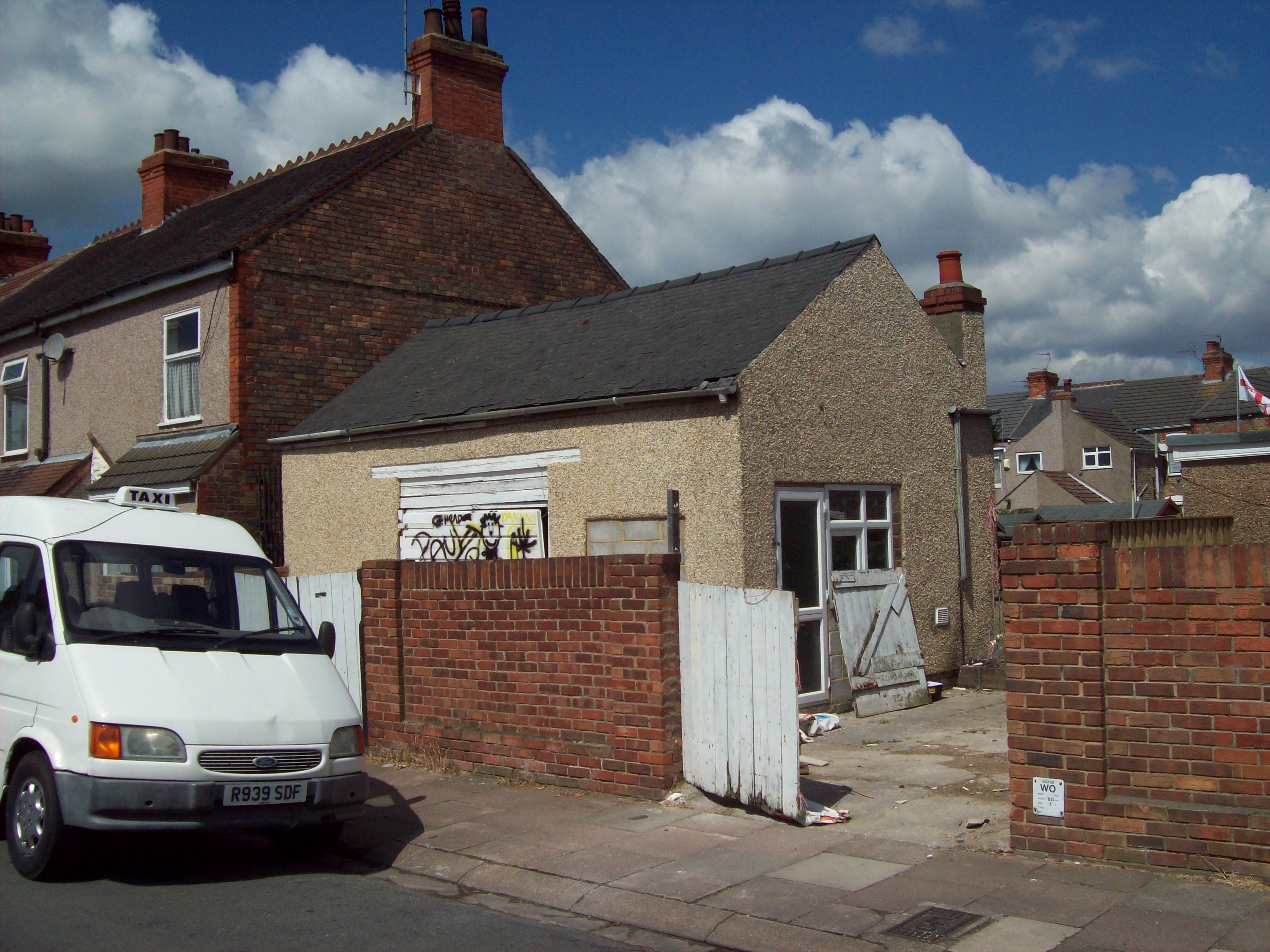 The derelict garage presenting a blot on the current street scene
